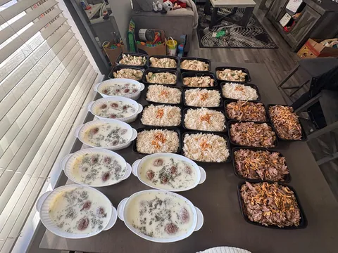 A long table set with many individual meals and family trays.