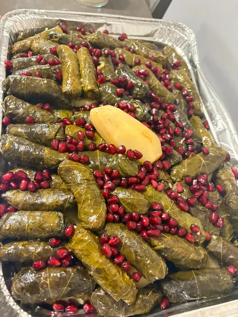 A tray of grape leaves garnished with pomegranate and lemon.
