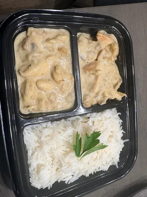 An individual meal with rice and a creamy stew.
