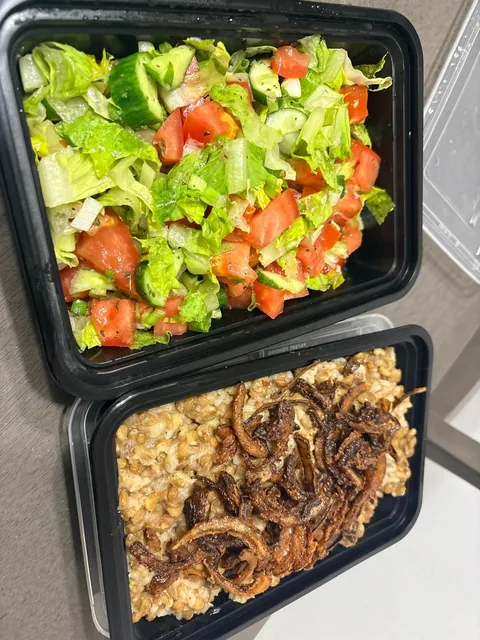 A rice and lentil meal with browned onions and a fresh salad.