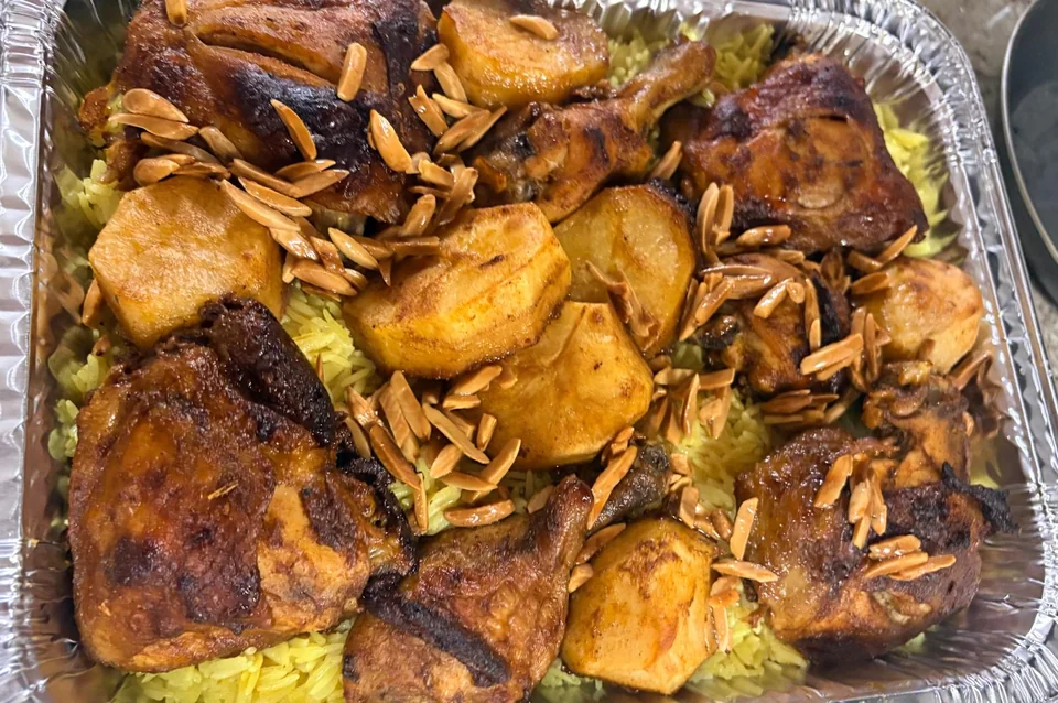 A close view of roasted chicken pieces over golden rice.