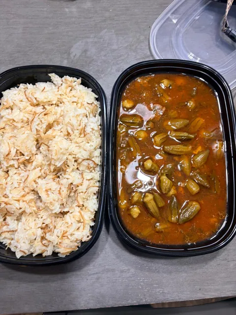 An individual rice portion beside a red vegetable stew.