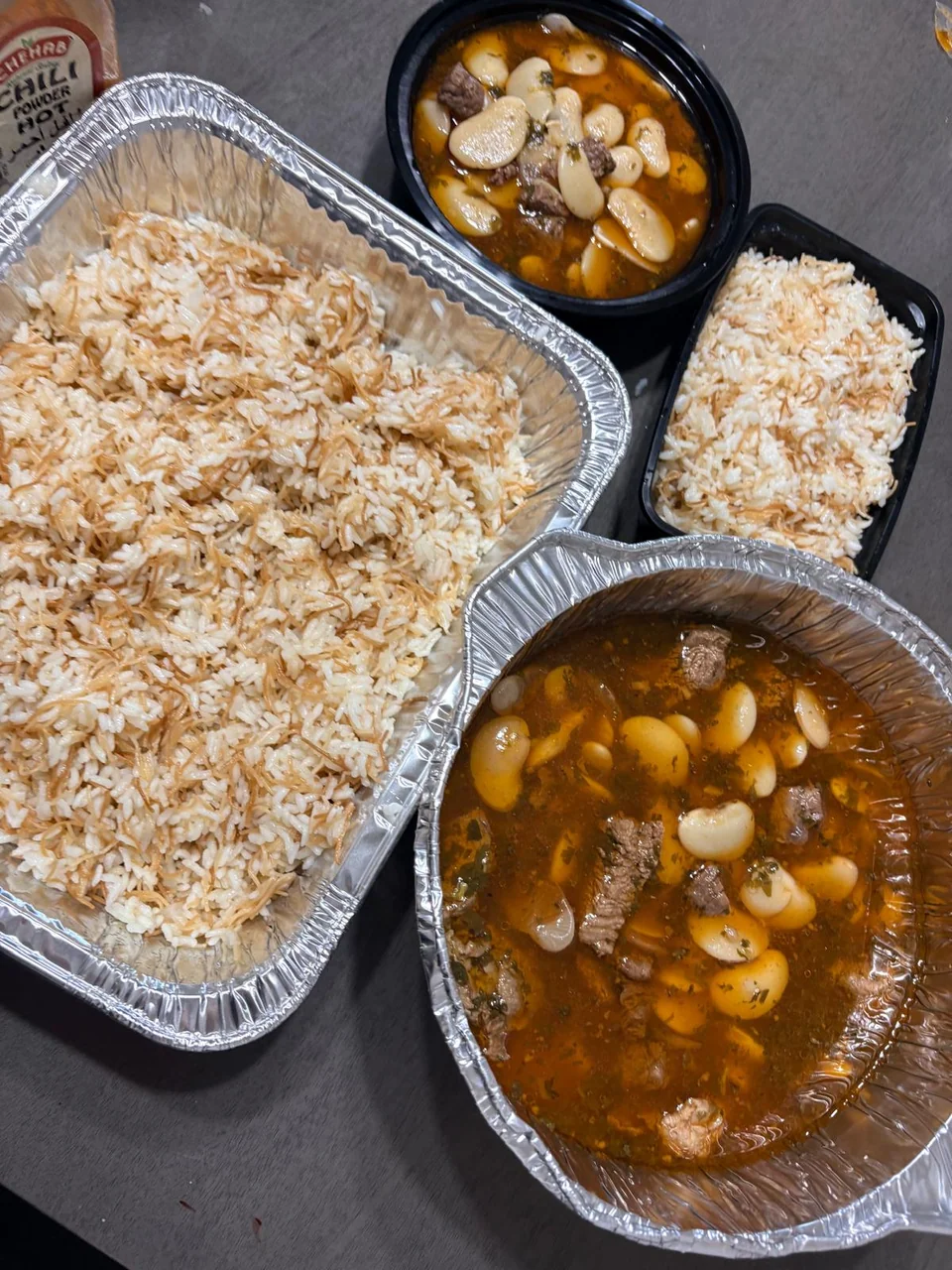 A family rice tray and several bowls of vegetable stew.