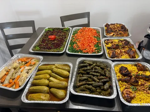 A full table of grape leaves, stuffed zucchini, rice, salad and other family trays.