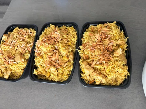 Three prepared portions of golden rice topped with browned onions.