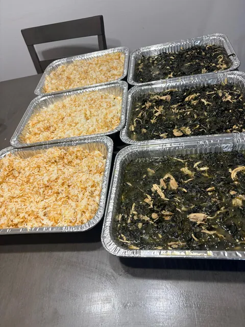 Large trays of cooked greens and fluffy rice ready for a gathering.